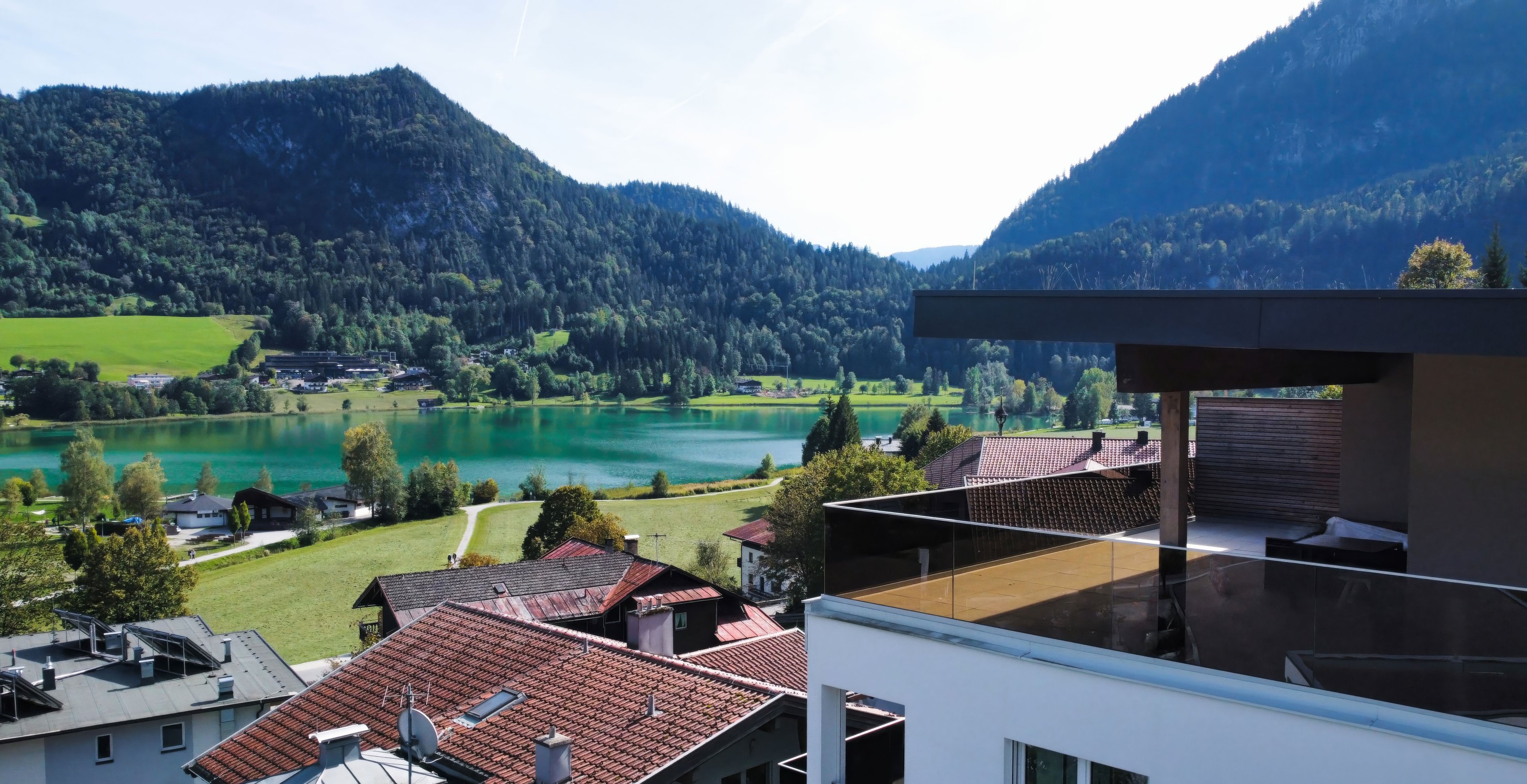 Weitläufige Umgebungsaufnahme mit See, Berglandschaft und Wohnbebauung in Tirol